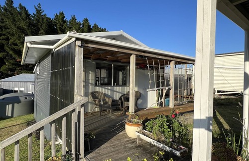 Kawhia Cottage | Cosy Aotea Cottage with water views, a gentle stroll to the beach. Pet Friendly!
