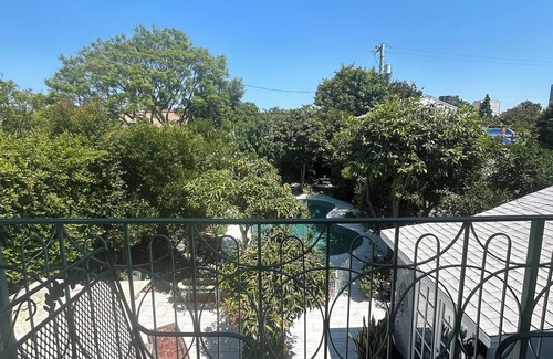 Mid City House | Historic Hollywood Haven in LA with Lush Garden, Balconies & Star-Studded Past
