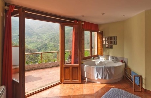 Fresnedo Cottage | Jacuzzi in bedroom with mountain views, barbecue and fireplace