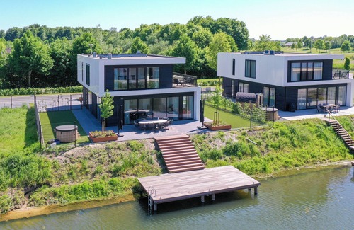 Biddinghuizen House | Luxury 8-person villa on the water with hot tub, private jetty, spacious terrace and 4 bedrooms. Located at Villa Resort Harderwold, near Harderwijk and the Veluwemeer!