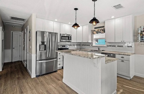 Fort Myers Beach House | Ostego Charm: Open floor plan, pool, porch, lush landscape—walk-able to the Beach!