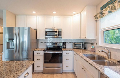 Fort Myers Beach House | Ostego Charm: Open floor plan, pool, porch, lush landscape—walk-able to the Beach!