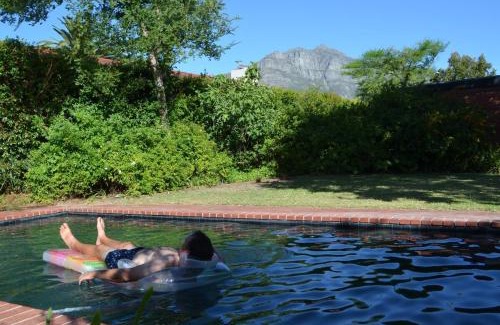 Die Boord House | Retro Red Stone Villa with pool & lush garden
