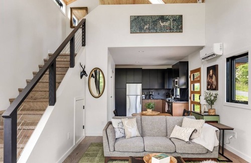 Young Harris Cabin | Romance meets design at Viking Hut, a Scandinavian 1BR retreat in the North Georgia mountains. Floor-to-ceiling windows frame fiery fall leaves, a skylight invites stargazing from your king bed, and a fenced yard makes it perfect for pups.