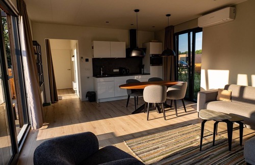Lattrop House | The Amalia is a 4-person holiday home featuring a cozy, homely living room with an open kitchen, 2 bedrooms, a spacious outdoor area, and a hot tub.
