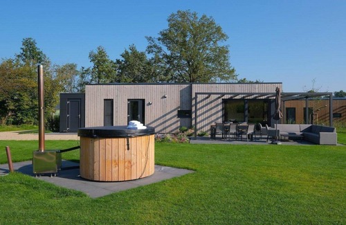 Lattrop House | The Amalia is a 4-person holiday home featuring a cozy, homely living room with an open kitchen, 2 bedrooms, a spacious outdoor area, and a hot tub.