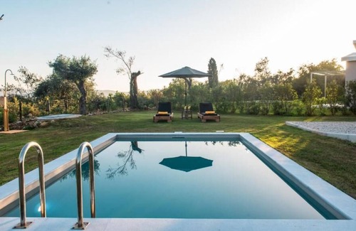 Ano Korakiana Villa | The villa's large private garden leads directly to the outdoor private pool.