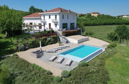 Castagnole delle Lanze Villa | Villa with vineyards, infinity pool, views of an UNESCO castle and the alps.