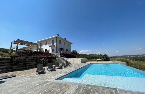 Castagnole delle Lanze Villa | Villa with vineyards, infinity pool, views of an UNESCO castle and the alps.