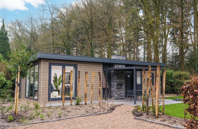 Enjoy a luxury holiday home in the wooded nature of the Veluwe, featuring modern amenities, air conditioning, and a stylish pergola for optimal comfort.