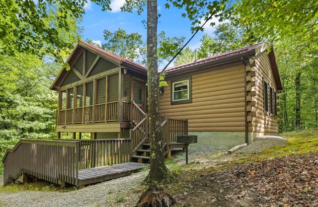 Log Home with fenced in deck & screen porch, cosmopolitan style ranch design.