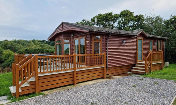 Grampound House | Beautiful Willow Lodge 67-4-6 persons-Private Hot Tub-Pet Friendly-Tranquil holiday away from it all yet not far to St Austell-The Holiday Home has two bedrooms, living & dining area, equipped kitchen -Decking-Al Fresco dining-Fishing lakes-Pet friendly