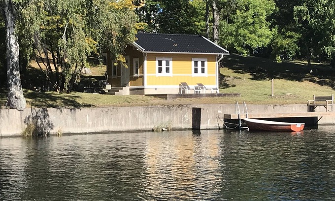 Boo House | Cottage with sunny wooden deck by water. Rowing boat included.