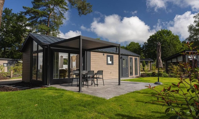 Lieren House | Enjoy a luxurious holiday home for 4 people in the wooded nature of the Veluwe, complete with modern amenities, air conditioning, and a stylish pergola for optimal comfort. Additionally, unwind in the private hot tub, perfect for relaxing after a day