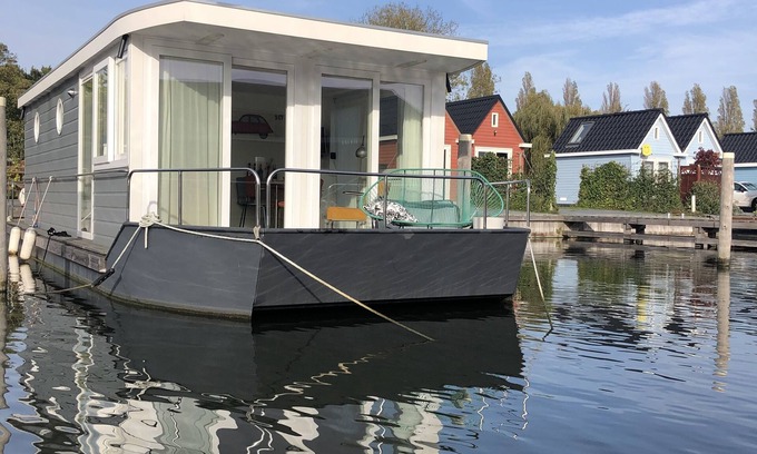 Stavoren Boat Rental | Modern houseboat in quiet harbor close to the IJsselmeer with SUPs and canoe