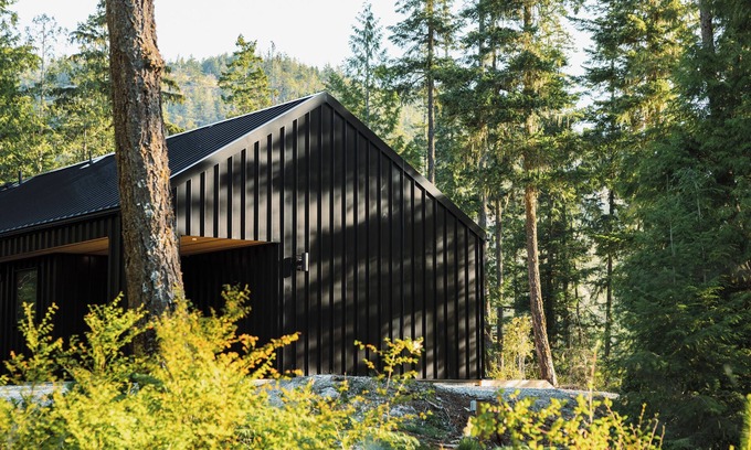 Garden Bay House | Scandinavian-inspired black cabin with cedar hot tub in a private forest.