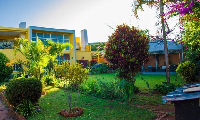 Ambohibao Villa | The white-orange bedroom with a pleasant view overlooking the lake